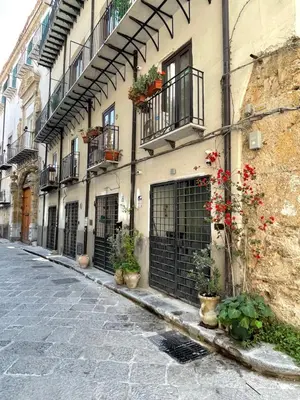 a building with gates and potted plants on a street at Il corvo e la volpe in Palermo