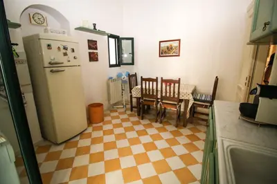 a kitchen with a refrigerator and a table and chairs at Il Gelsomino in Palermo