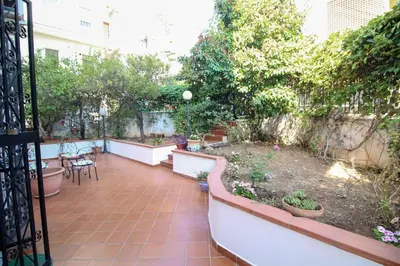 a balcony with a garden with a table and chairs at Il Gelsomino in Palermo