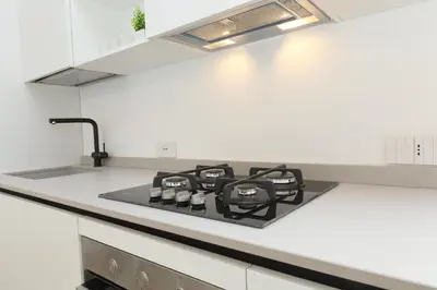 a kitchen with a stove top in a white kitchen at Villa Beba in Cefalù
