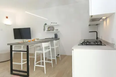 a kitchen with a counter and a table with stools at Villa Beba in Cefalù