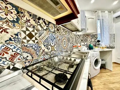 a kitchen with tiles on the wall and a stove at MD APARTAMENT CORAL BAHLARA in Palermo