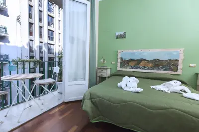 a bedroom with a green bed with towels on it at Stupor Mundi Bed and Breakfast in Palermo
