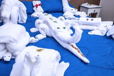 a bed with white stuffed elephants and towels on it at Stupor Mundi Bed and Breakfast in Palermo