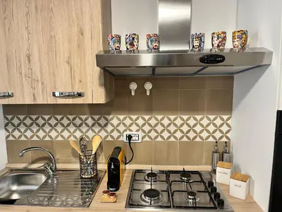 a kitchen with a stove top and a sink at Nigra Apartments in Palermo