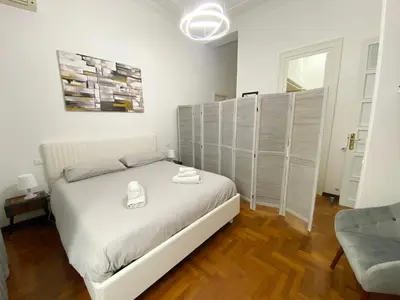 a bedroom with a white bed and a couch at Kamaffari Central Apartment in Palermo