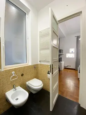a bathroom with a toilet and a sink and a window at Kamaffari Central Apartment in Palermo