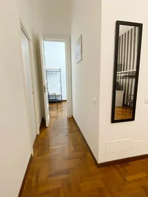 a hallway with a mirror and white walls and wooden floors at Kamaffari Central Apartment in Palermo