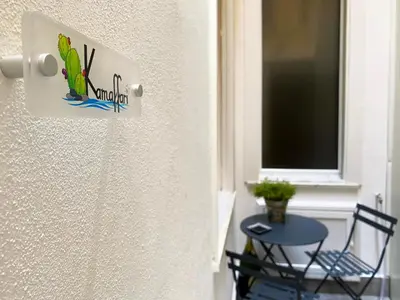 a door with a sign on it next to a table at Kamaffari Central Apartment in Palermo