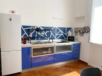 a blue kitchen with a sink and a refrigerator at Kamaffari Central Apartment in Palermo