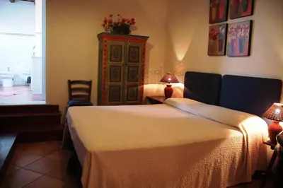 a bedroom with a bed and a dresser and a window at Punto de Vista B&B Makari in San Vito lo Capo