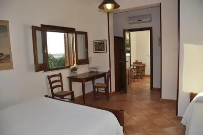 a bedroom with a bed and a table and chairs at Punto de Vista B&B Makari in San Vito lo Capo