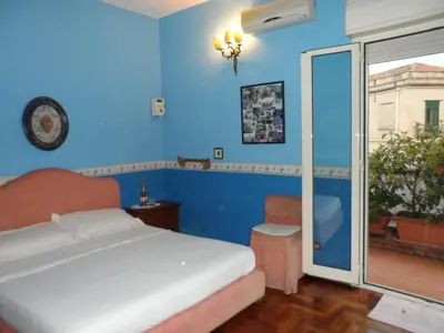 a bedroom with blue walls and a bed and a window at Alle Terrazze del Borgo Vecchio in Palermo