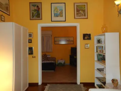 a living room with yellow walls and an open door at Alle Terrazze del Borgo Vecchio in Palermo