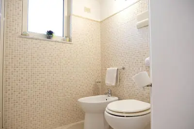 a white bathroom with a toilet and a window at Appartamento nel centro storico di Palermo - Via Meli's House in Palermo