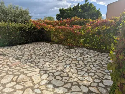 a stone walkway in front of some bushes at Villa Oasi del Relax Flavianna in Castellammare del Golfo