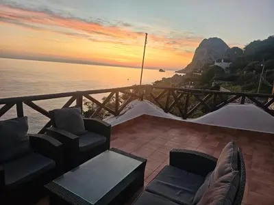 a patio with chairs and a table with a view of the ocean at Mare e cielo in Porticello