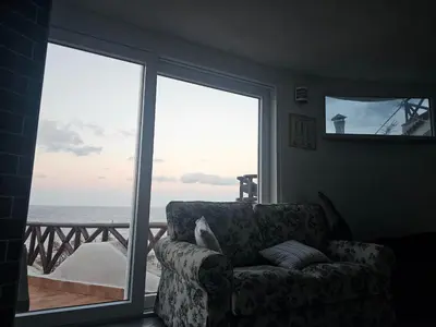 a living room with a couch and a view of the ocean at Mare e cielo in Porticello