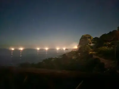 a foggy night with lights on a cliff at Mare e cielo in Porticello