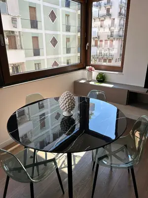 a glass table and chairs in a room with windows at SPRING APARTMENTS in Palermo