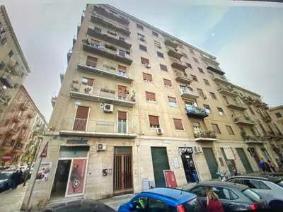 a tall building with cars parked in front of it at Casa Michela in Palermo