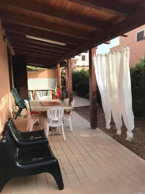 a patio with a table and chairs and awning at Casa al mare a Campofelice di Roccella - Cefalù in Lascari