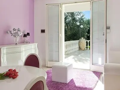 a living room with a white table and a large sliding glass door at Villa Rachele con piscina in Balestrate