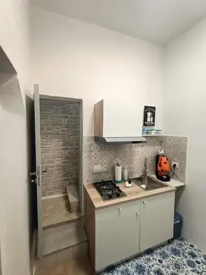 a small kitchen with a sink and a stove at La casetta di Toto' in Isola delle Femmine