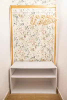 a white shelf in a closet with a floral wallpaper at Pilly House Rinascente in Palermo