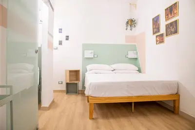 a bedroom with a bed with white sheets and pillows at Pilly House Rinascente in Palermo