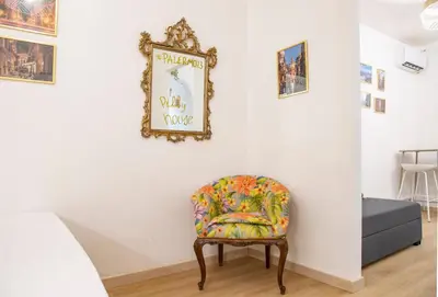 a chair in a room with a mirror on the wall at Pilly House Rinascente in Palermo