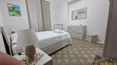 a bedroom with a bed and a table with a lamp at CasaVe in Palermo
