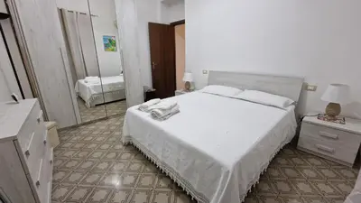 a bedroom with a large white bed and a mirror at CasaVe in Palermo