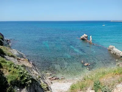 a patio with a table and chairs under a wooden pergola at LE SORELLE entire villa sea view in Scopello