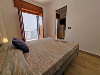 a bedroom with a large bed with a large window at Casa di Leda 2 in Santa Flavia