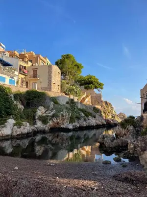 a river with houses on the side of a hill at Casa di Leda 1 in Santa Flavia