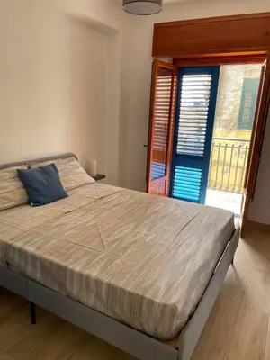 a bedroom with a large bed and a window at Casa di Leda 1 in Santa Flavia