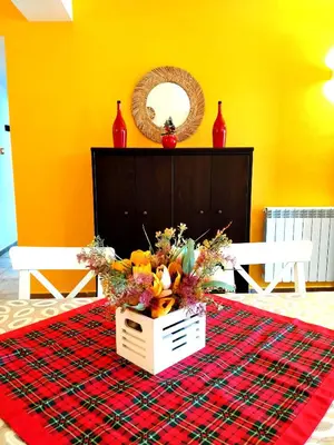 a table with a basket of flowers on a red blanket at Alvarado - Your Home in Sicily in Carini