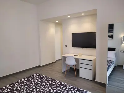 a bedroom with a desk and a bed and a tv at SP Rooms in Isola delle Femmine