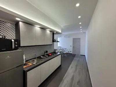a kitchen with white cabinets and a counter top at SP Rooms in Isola delle Femmine