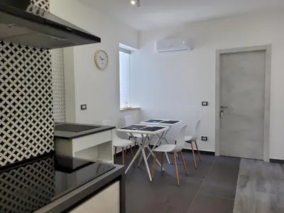 a kitchen and dining room with a table and chairs at SP Rooms in Isola delle Femmine