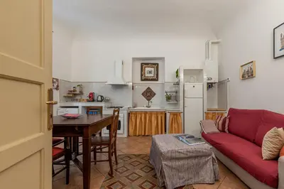 a living room with a red couch and a table at Casa Marettu in Palermo