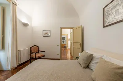a bedroom with a bed and a chair at Casa Marettu in Palermo