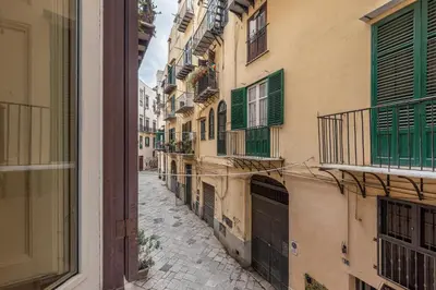 an empty alley with green shutters on a building at Casa Marettu in Palermo