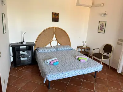 a bedroom with a bed with a wooden head board at Villacinisi in Cinisi