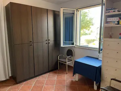 a bedroom with a cabinet and a table and a window at Villacinisi in Cinisi