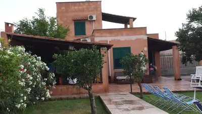 a house with chairs and a yard with a building at Villacinisi in Cinisi