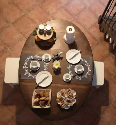 a wooden table with plates and food on it at Casa degli Allori in Palermo