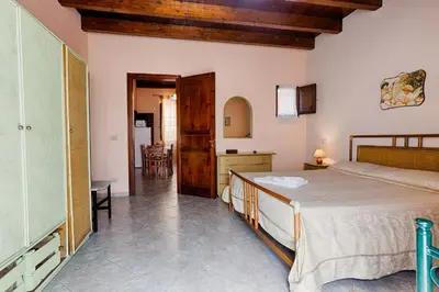 a bedroom with a bed and a dining room at GuestHost - Corso Garibaldi - Castellammare Central Flats in Castellammare del Golfo