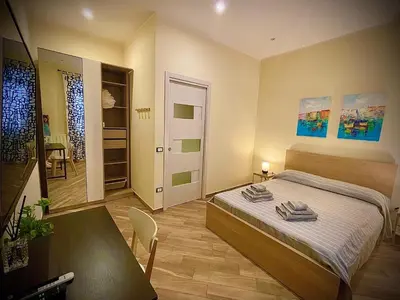 a bedroom with a bed and a table and a dining room at Casa Batù alle porte del Capo in Palermo